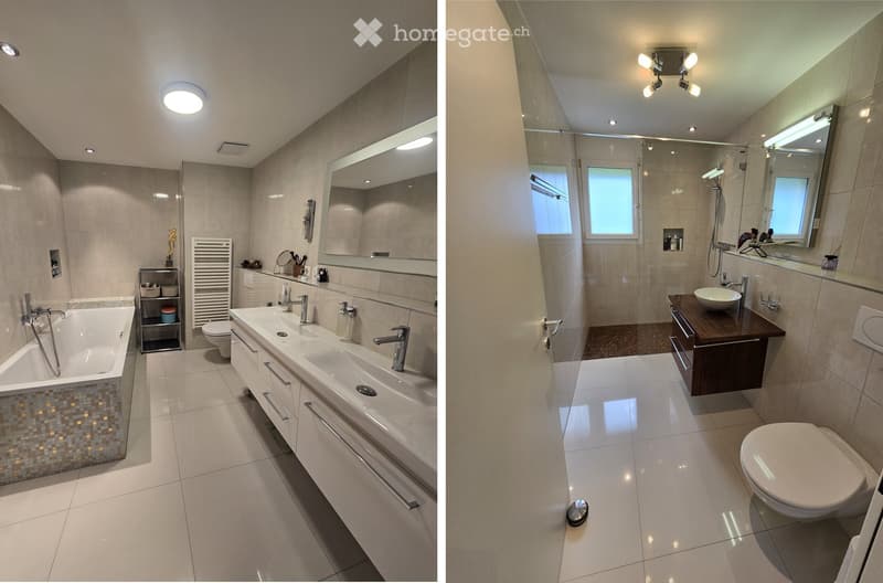 Modern bathroom with a bathtub, double sink, toilet, large mirror, and a separate shower area. Features include a radiator, modern lighting, and a wooden vanity with a sink and storage.