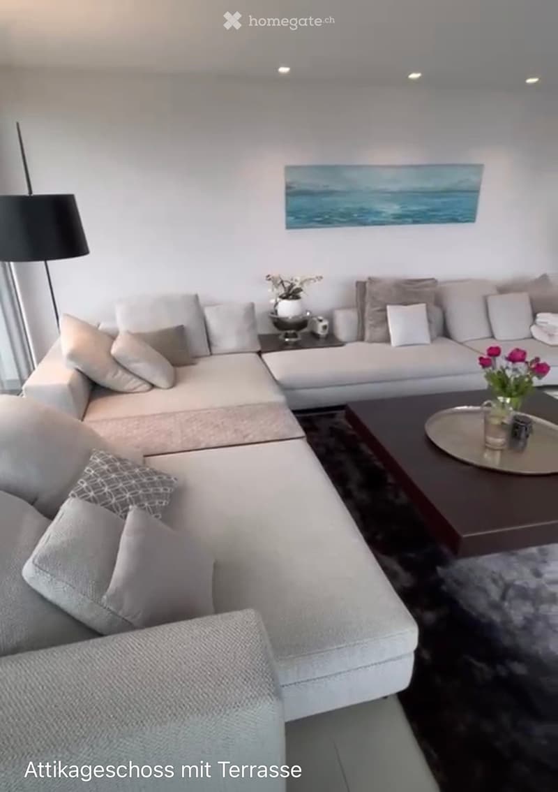 Modern living room with a large sectional sofa, coffee table, floor lamp, and decorative vases.