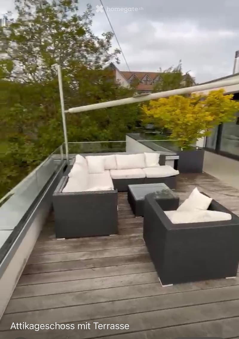 Roof terrace with wooden decking, white outdoor sofa set, coffee table, and potted plants.