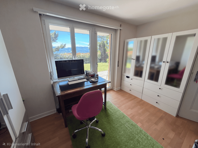 Bright, modern room with wooden flooring, large windows, a desk with a computer, a pink office chair, and a white wardrobe with mirrored doors.