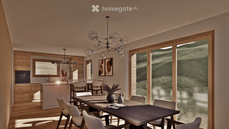Modern open-plan dining and kitchen area with wooden flooring, large windows, a dark wooden dining table surrounded by white chairs, a kitchen island with bar stools, and a chandelier with glass globes.