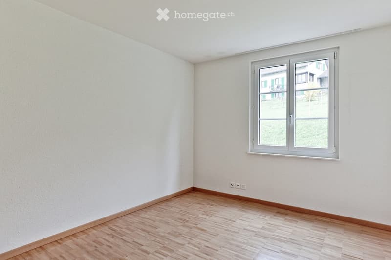 white walls, wooden floors, window with view to the outside