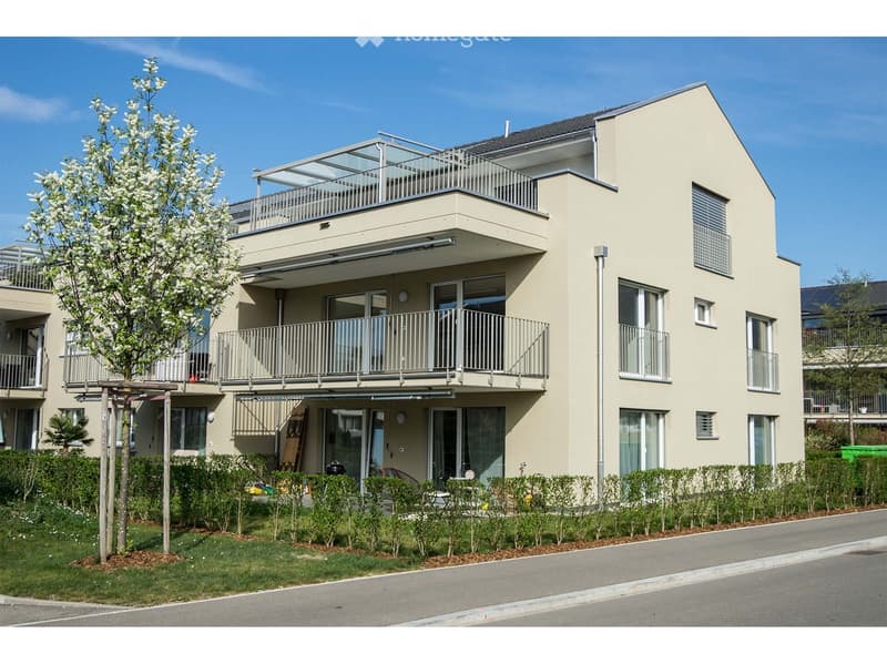 3 story house, beige exterior, multiple balconies, glass doors, windows, garden, street view