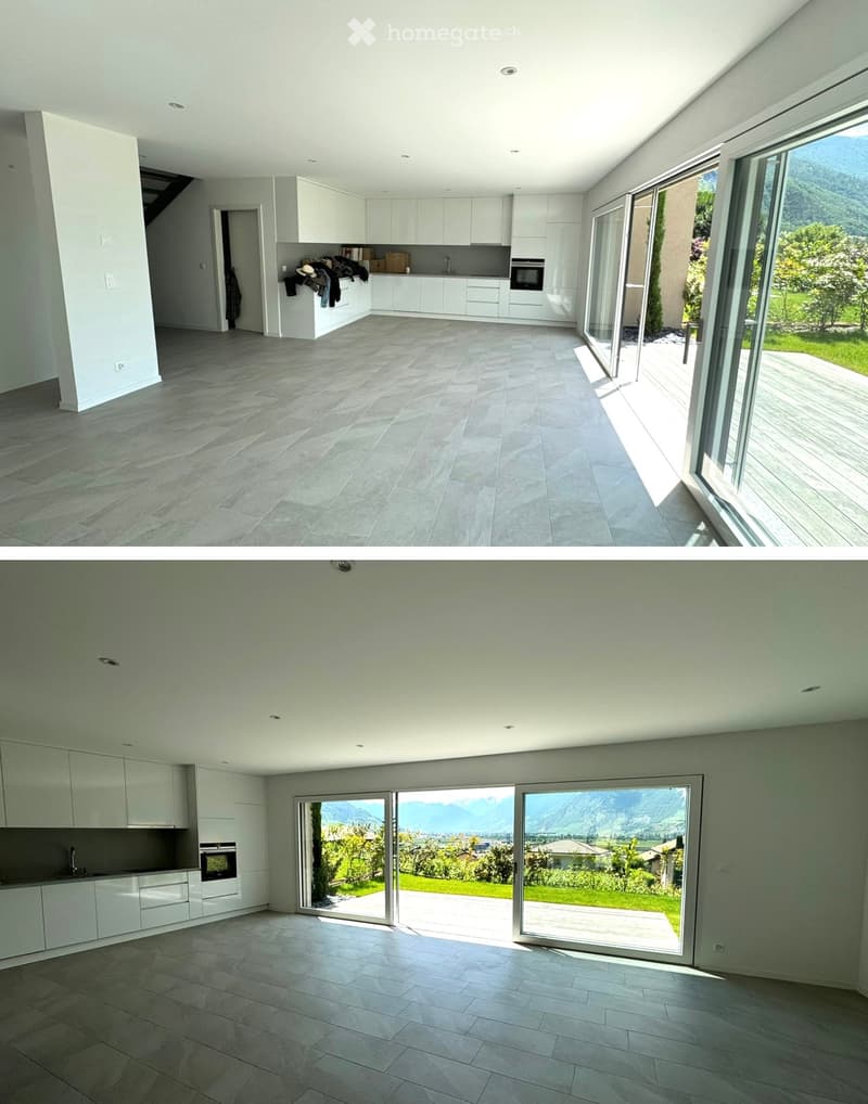 Modern, minimalist kitchen with white cabinets, grey tiled floor, and large sliding glass doors offering a scenic mountain view.