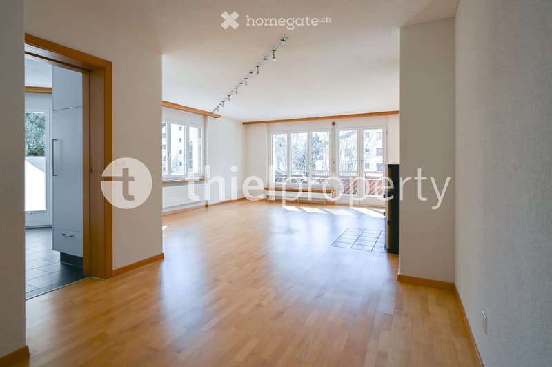 Empty room with wooden flooring, large windows, and white walls. No furniture or equipment present.