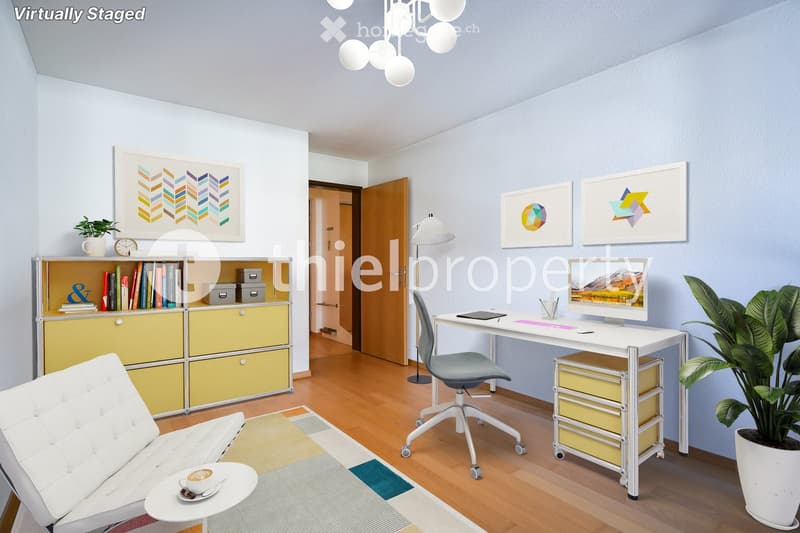 Modern, well-lit room with a white sofa, coffee table, desk with a computer, bookshelf, and decorative plants.