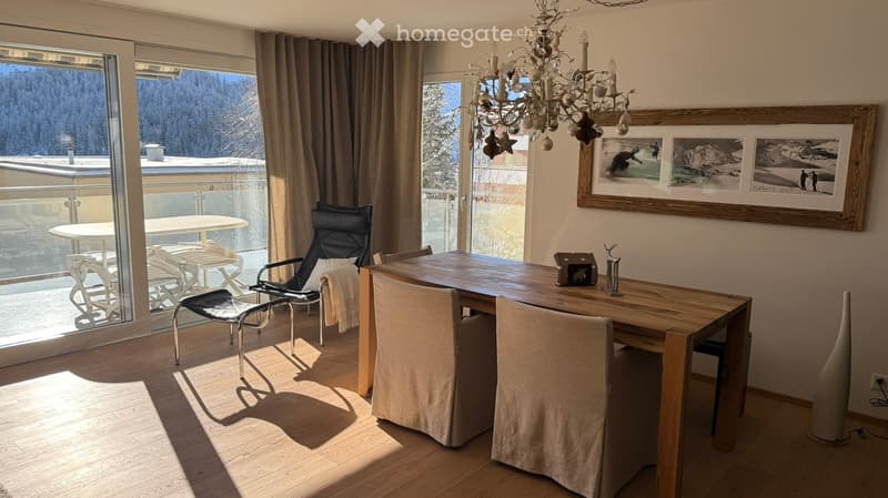 glass doors to terrace, large dining table, chandelier, framed photo on wall, wooden flooring