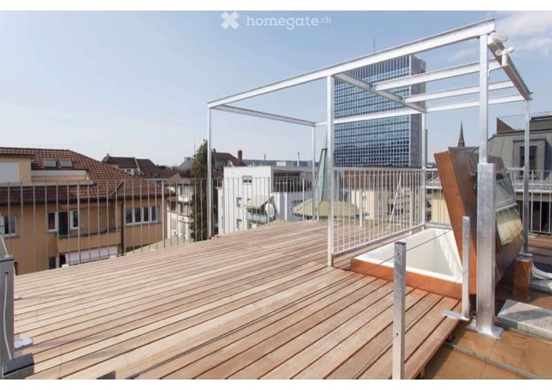 Wooden deck terrace with metal railing, modern cityscape view in the background.