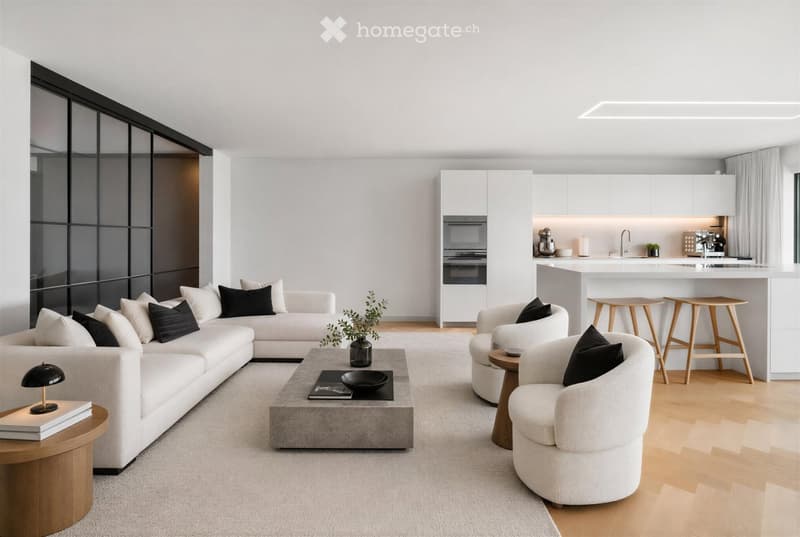 Modern living room with a white sectional sofa, coffee table, armchairs, and a kitchen area with a white island and built-in appliances.