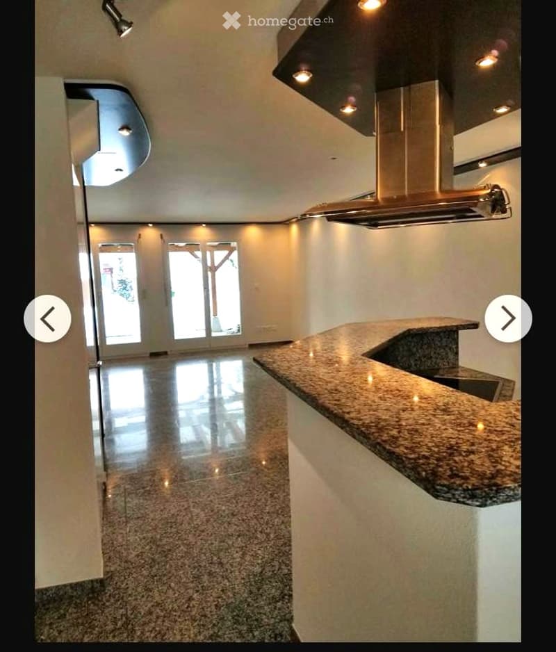 Empty room with polished granite floor, white walls, and a granite countertop with a sink. No furniture or equipment present.