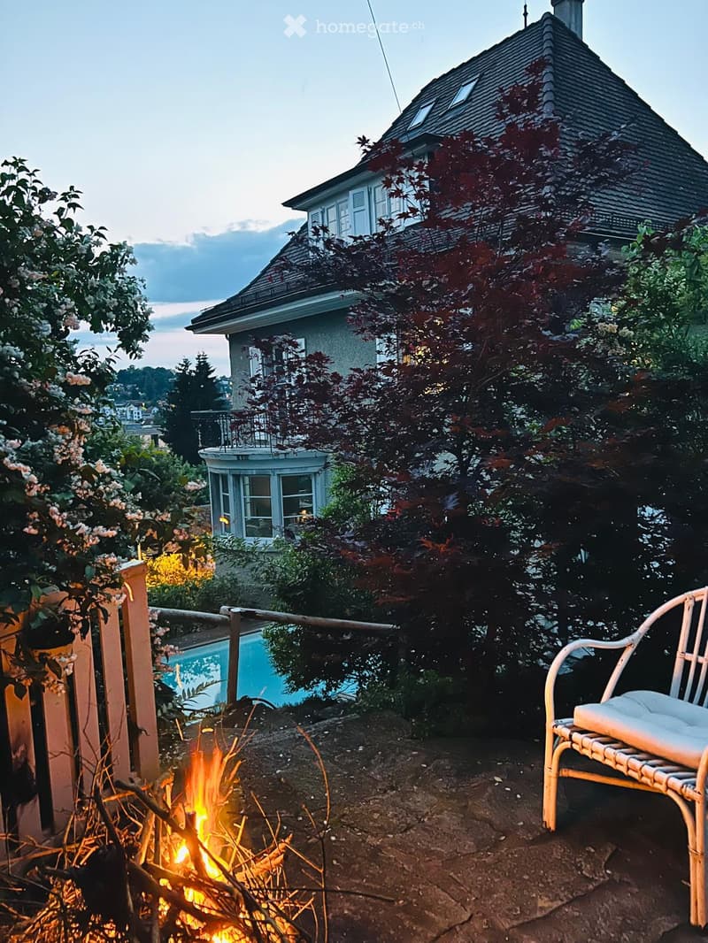 two story house, brick exterior, white windows, balcony, pool, trees, firepit, bench