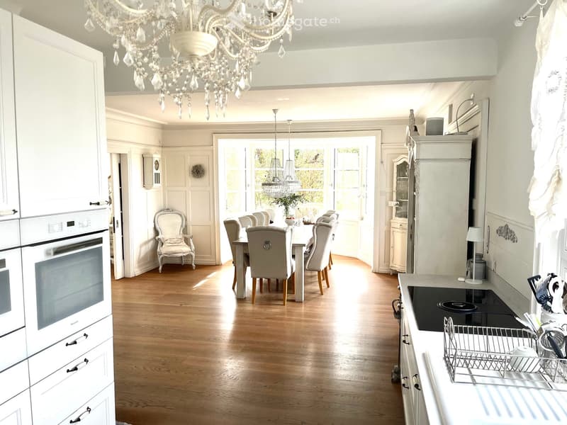 Chandelier, large kitchen with open floor plan, wooden floor, modern kitchen appliances, dining table, large windows
