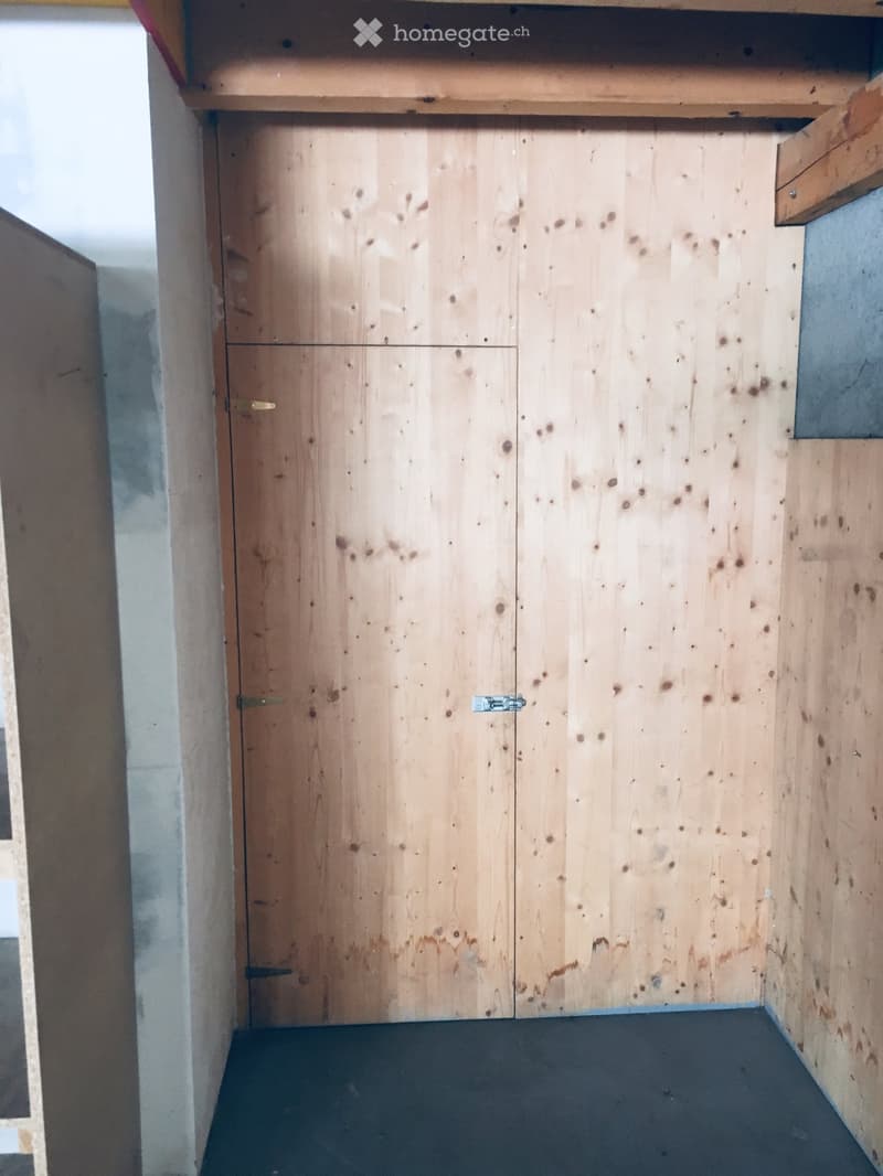 Empty room with wooden closet doors and a dark floor, no furniture or items present.