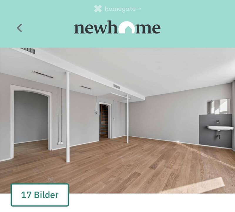 Empty room with wooden flooring, grey walls, and a small sink in the corner. No furniture or personal items are present.