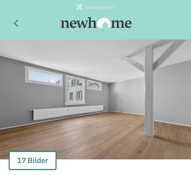 Empty room with wooden flooring, grey walls, large windows, and white radiator. No furniture or equipment present.