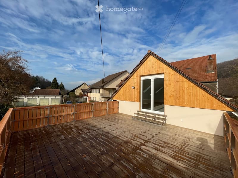 Raised wooden deck with railings, large glass doors leading to house, fenced perimeter