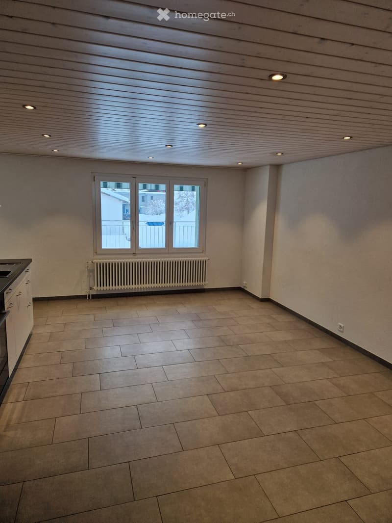Empty room with tiled floor, radiator, and a window with balcony