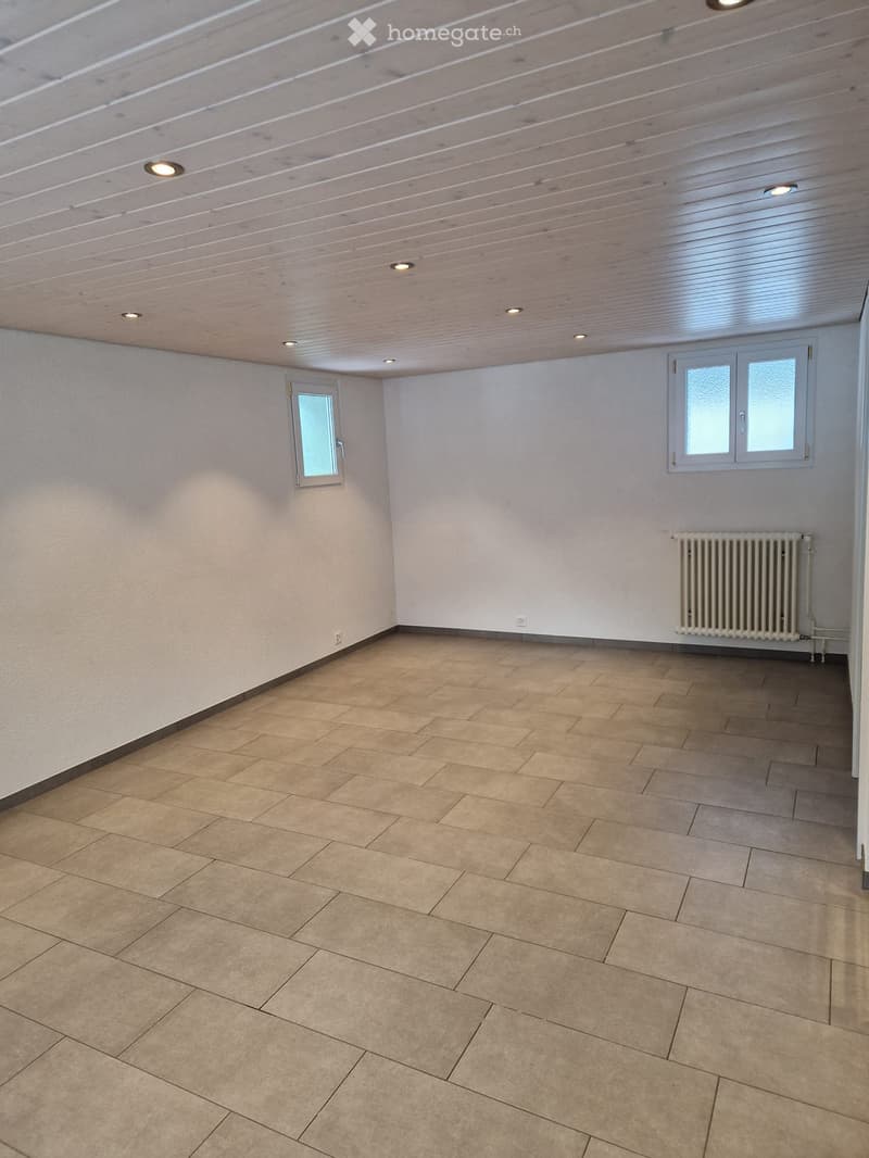 empty room with beige tiles, white walls, two windows, and a white radiator on the right wall