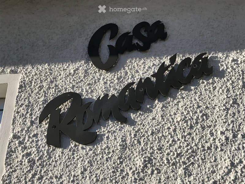 Exterior wall with the name "Casa Romantica" displayed in large, black letters.