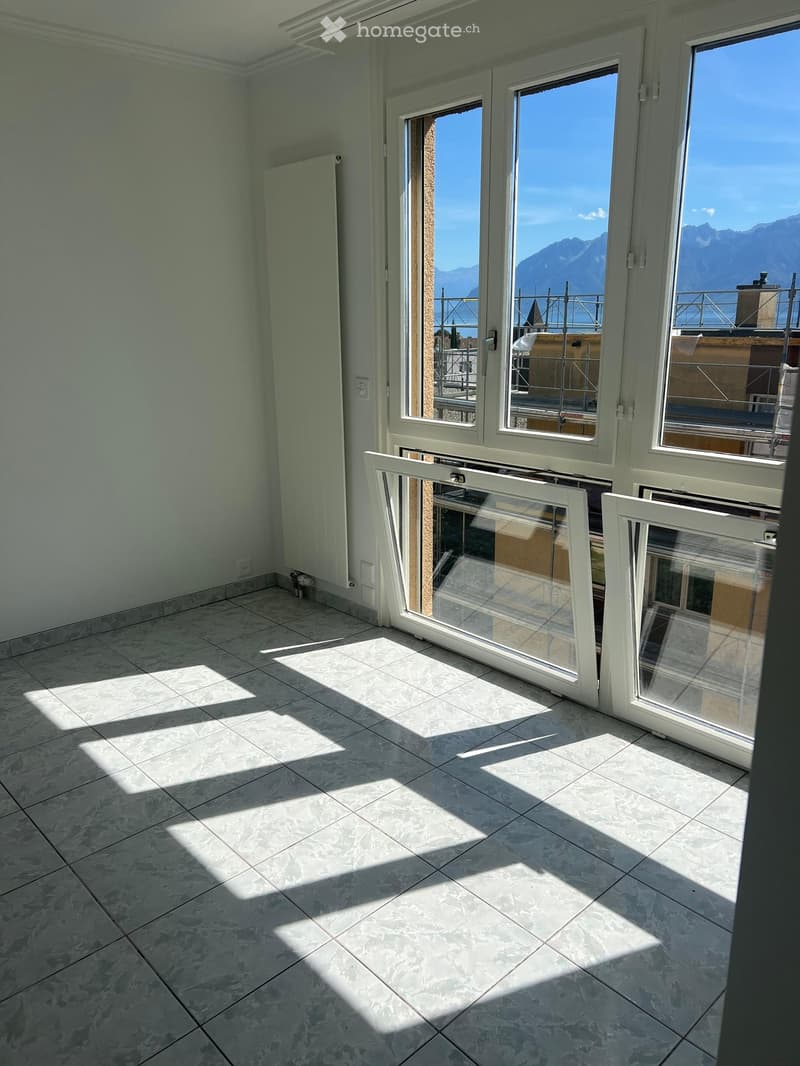 Empty room with tiled floor and large windows offering a scenic mountain view. No furniture or equipment present.