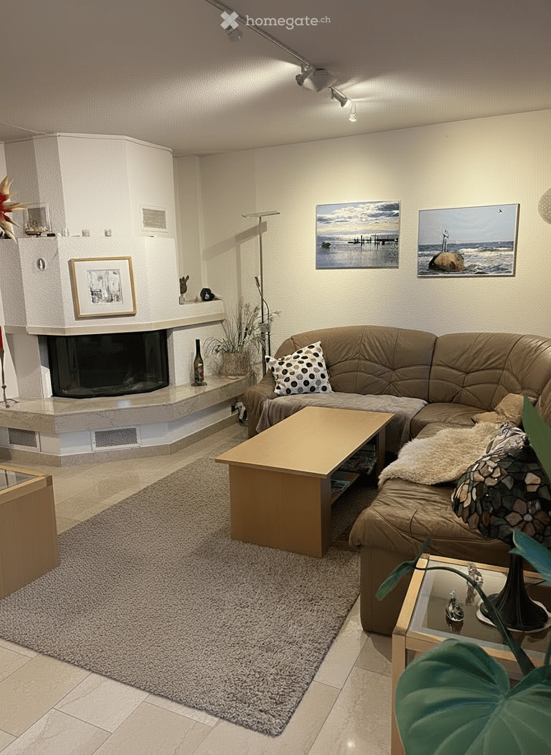 Modern living room with beige tiles, L-shaped sofa, wooden coffee table, gray carpet, fireplace, paintings on the wall, ceiling spotlights
