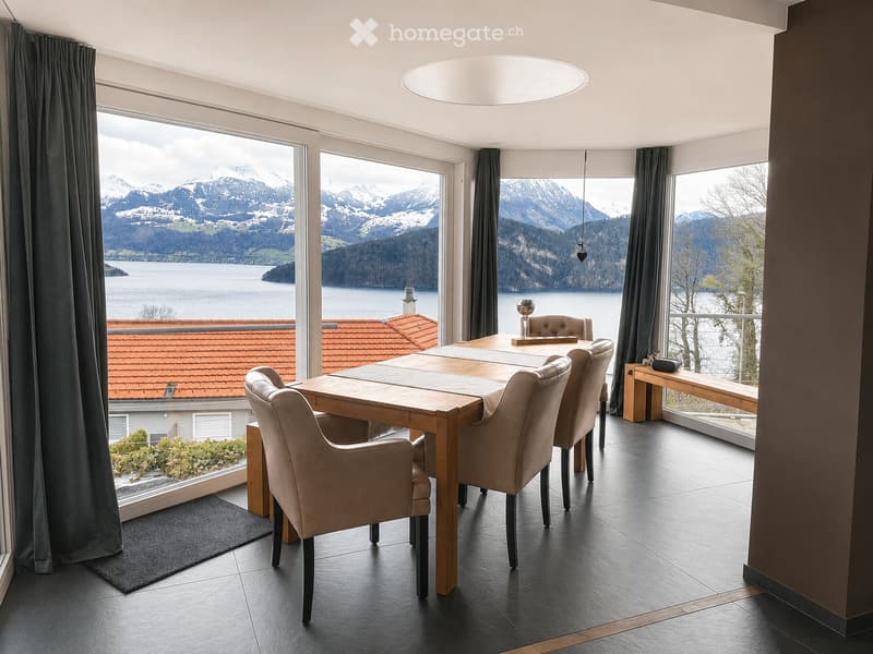 Modern kitchen with large windows offering a scenic mountain and lake view, featuring a wooden dining table, beige chairs, and a bench.