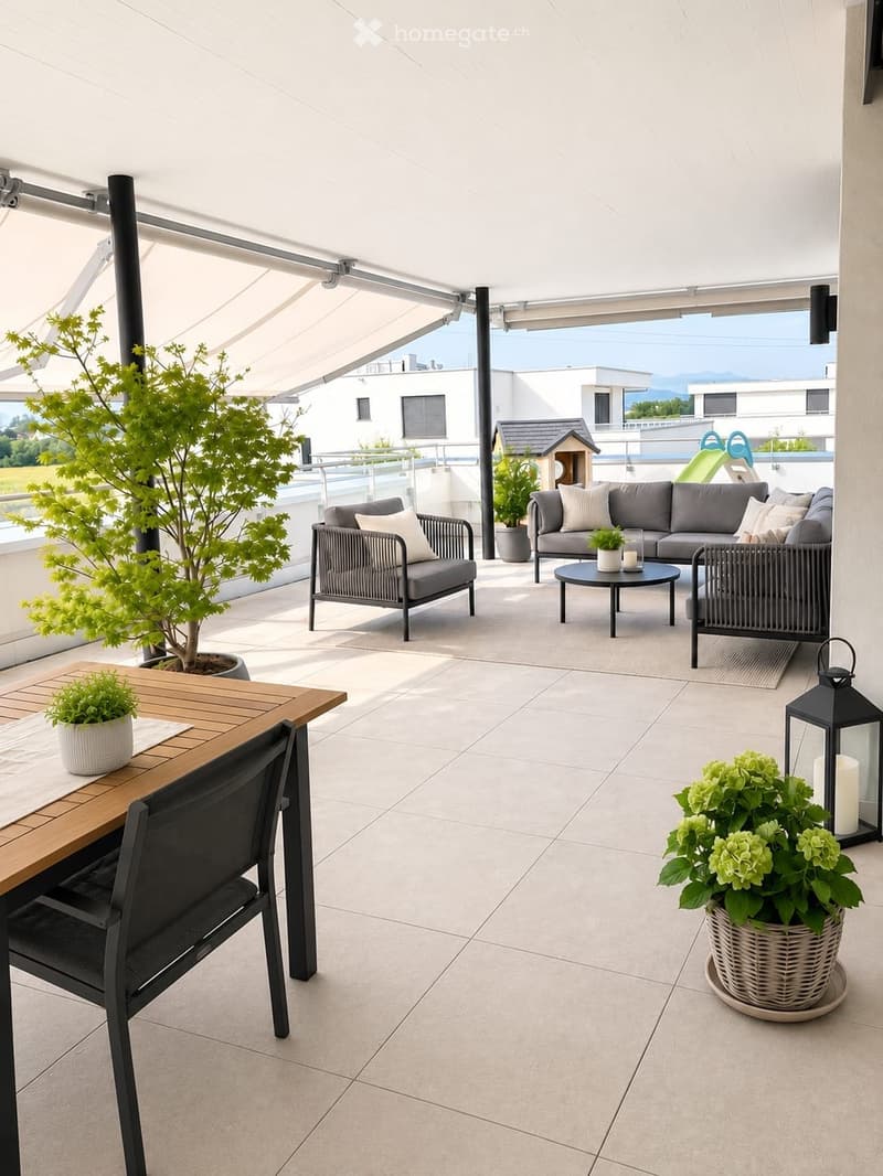 Modern balcony with tiled floor, grey sofa, wooden dining table, black chairs, and potted plants.