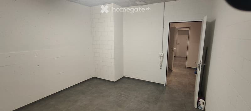 Empty room with white brick walls and a tiled floor, featuring an open doorway leading to another room.