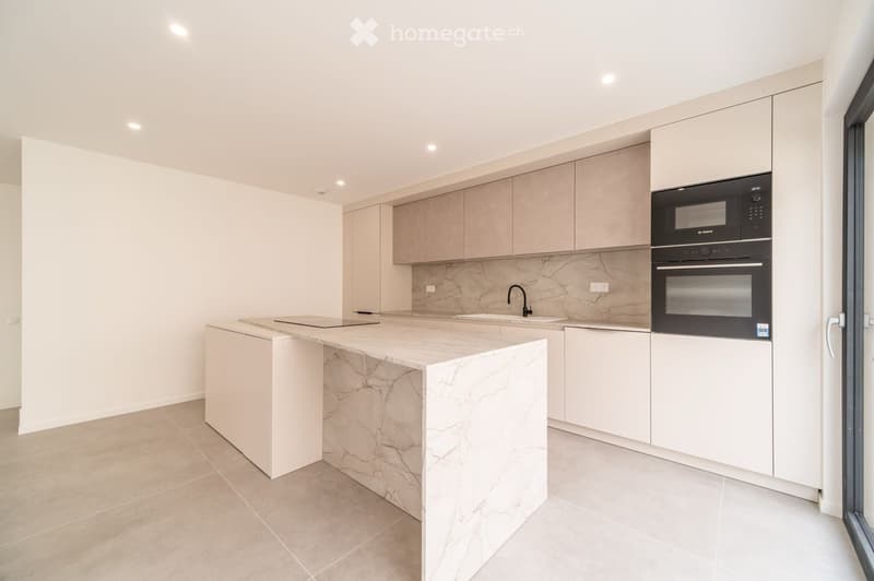 Modern kitchen with light-colored cabinets, marble countertop, built-in microwave and oven, and a sleek sink with a modern faucet.