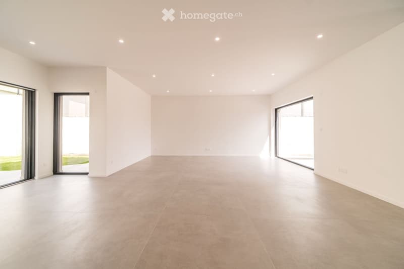 Empty room with white walls, light grey tiled floor, and large sliding glass doors leading to an outdoor area.