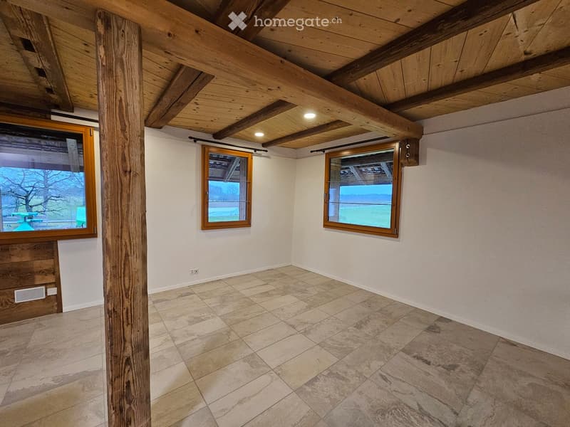 Empty room, tile flooring, wooden beams, three windows, power outlet