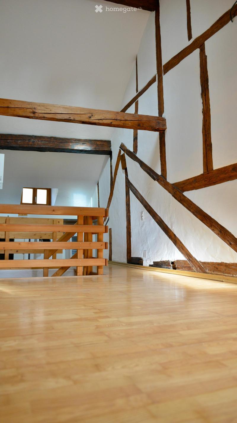 Empty room with wooden floor and wooden beams on the wall