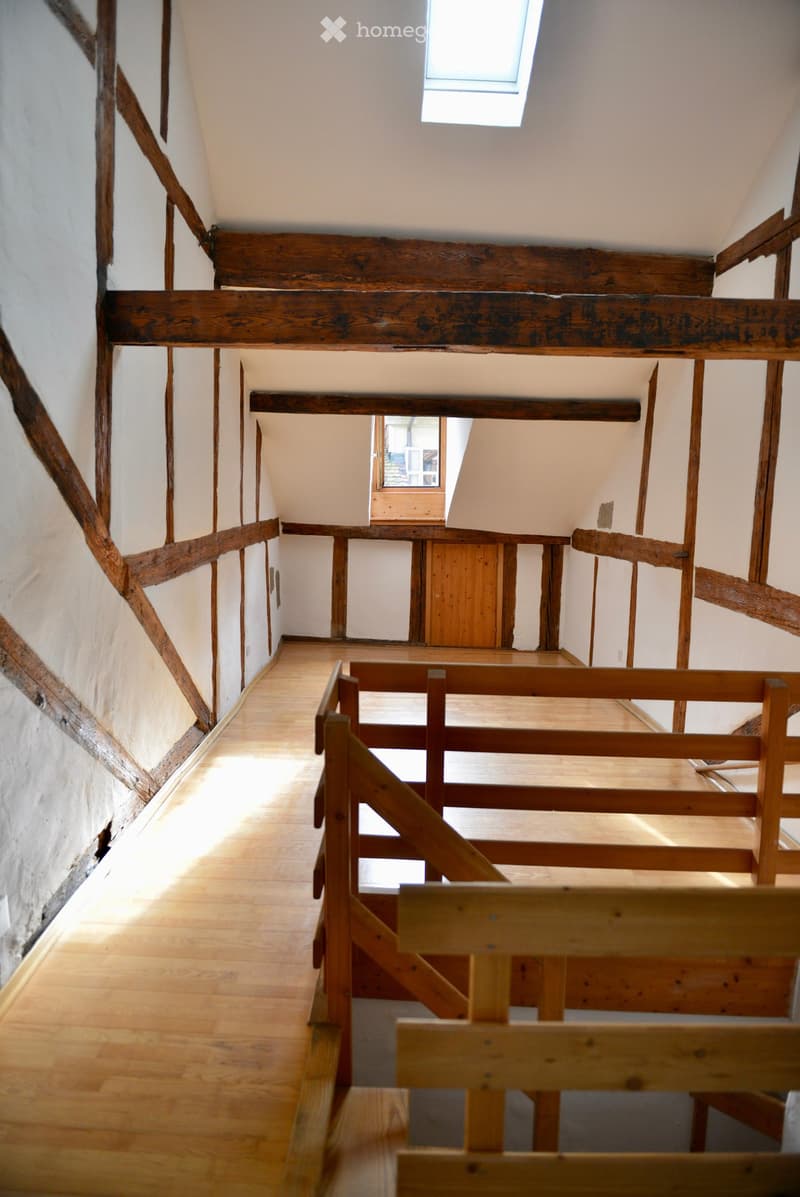 Raised wooden floor, wooden beams, wooden railings, wooden door, skylight