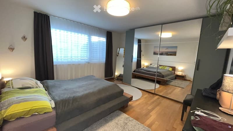 Two beds, rug, two lamps, mirror closet, window, light wooden floor