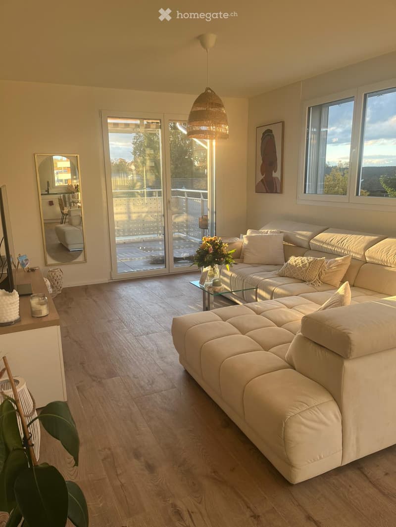 L-shaped white sofa, glass coffee table, mirror, framed picture, sliding doors, balcony