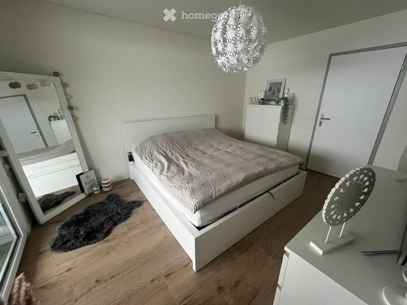 bedroom, white walls, white wooden bed, white wardrobe, mirror, wooden floor, large rug