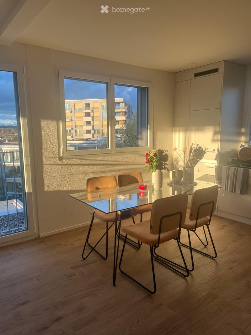 Dining room with glass table, 4 chairs, vase with flowers, view of the city