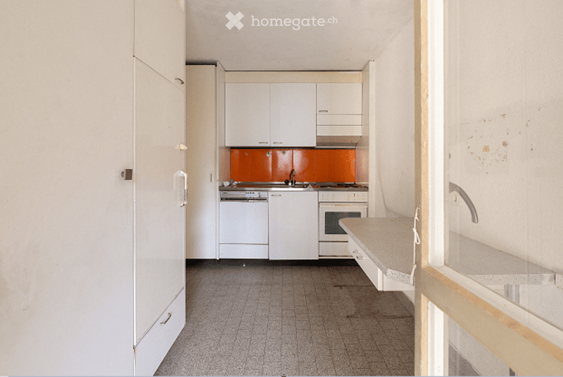 Modern kitchen with white cabinets, stainless steel appliances, and a tiled floor.