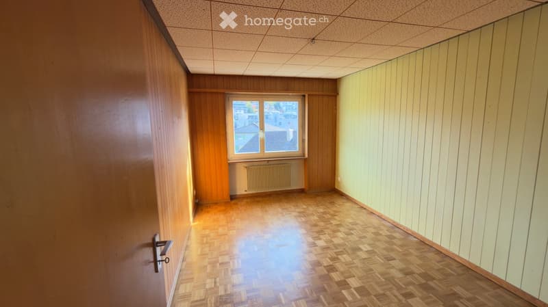 Empty room, parquet floor, wooden walls, window, radiator