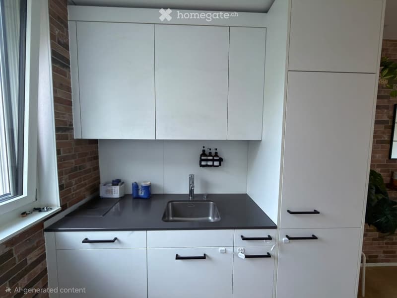 Modern kitchen with white cabinets, dark countertop, stainless steel sink, and a small window with brick wall visible.