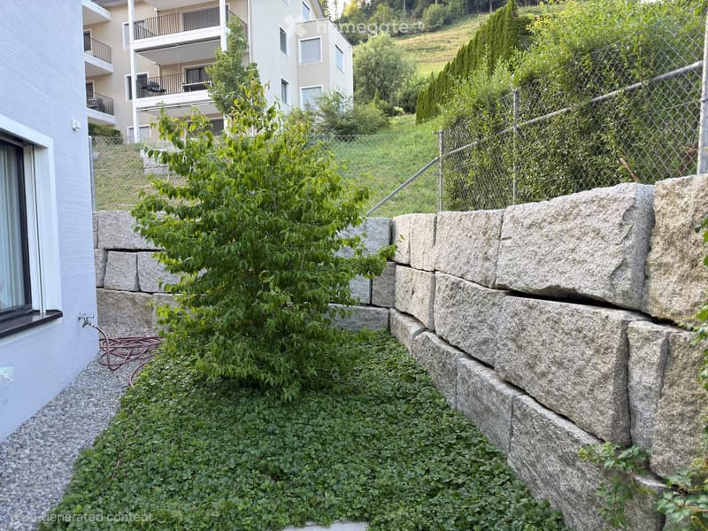 Garden area with stone retaining wall, small tree, and low-lying plants. A multi-story building with balconies is visible in the background.