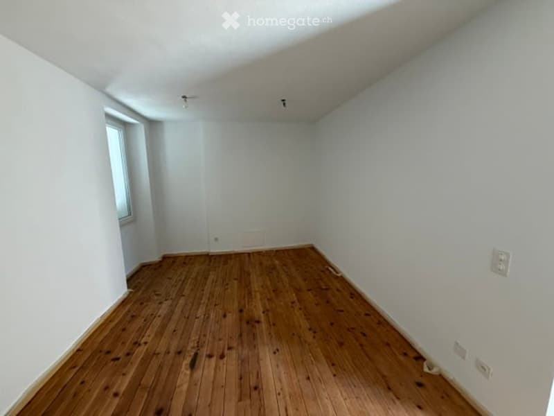 Completely empty room with white walls and wooden floor. No furniture or equipment.
