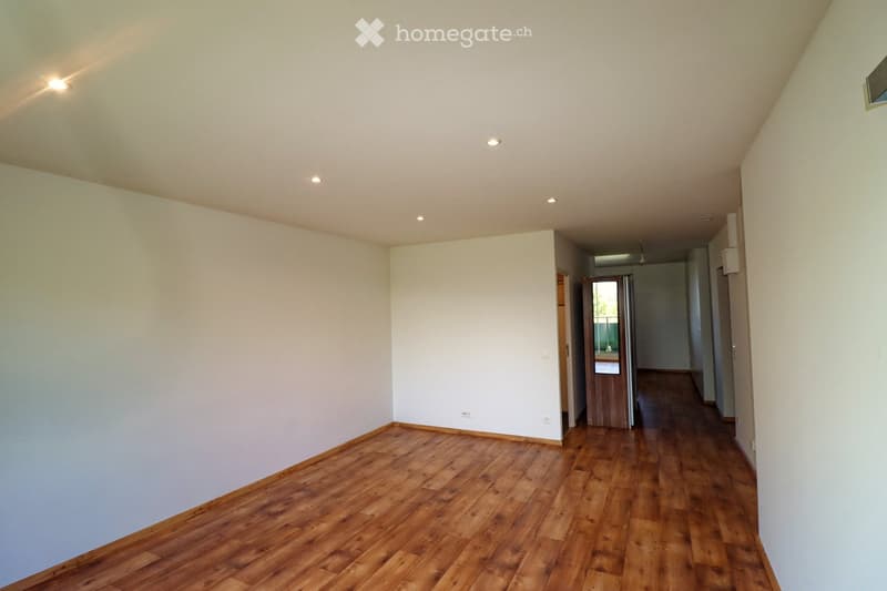 Empty room with wooden flooring, white walls, and recessed ceiling lights. No furniture or equipment present.