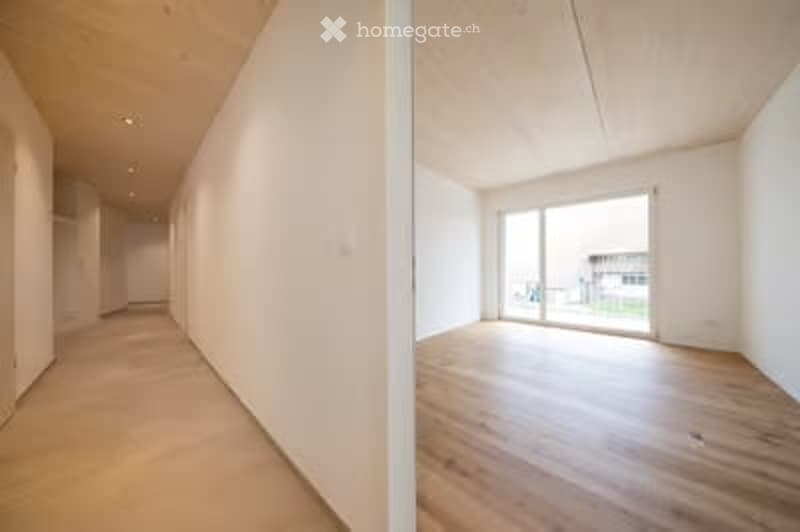 Two images showing an unfurnished room with light wooden flooring, white walls, and large windows with blinds. The room is empty with no furniture or equipment.