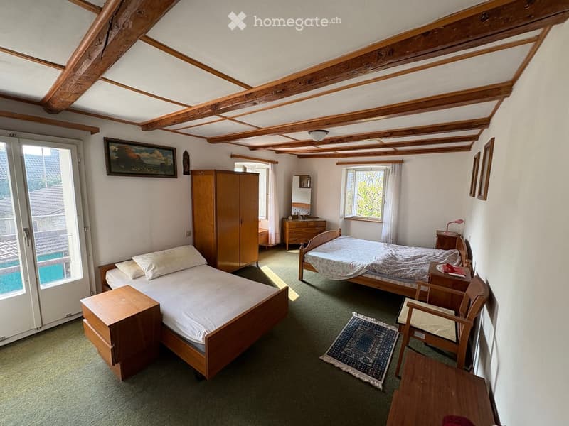 Bedroom with wooden beds, cabinet, and carpet, framed picture on the wall