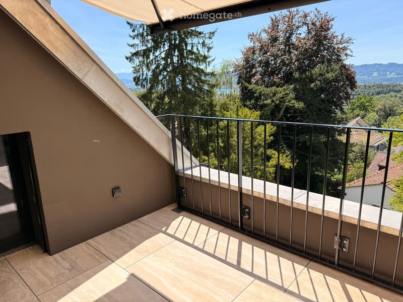Balcony with modern metal railing, tiled floor, and scenic view of trees and distant mountains.
