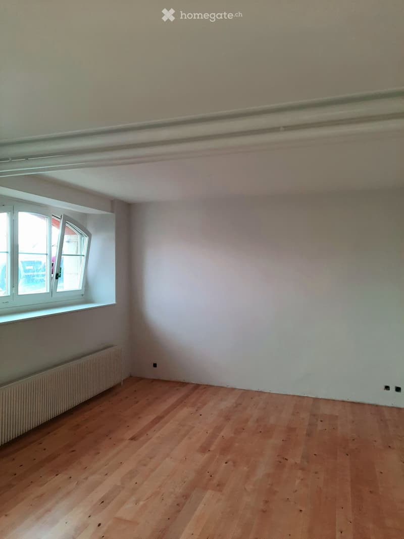 Empty room with wooden flooring, white walls, and a window with white frame. No furniture or equipment present.