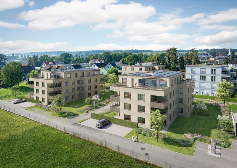 Aerial view of a modern residential complex with multiple apartment buildings, green spaces, and parking areas.