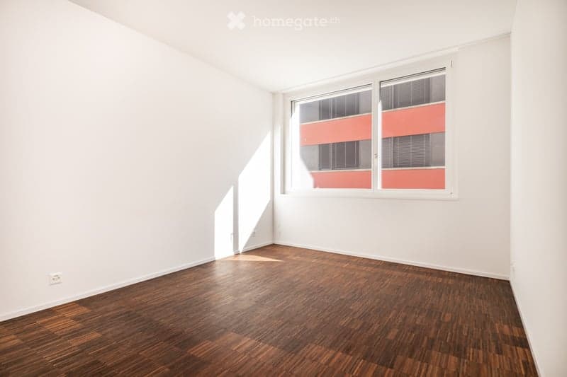 Completely empty room with white walls and wooden floor. No furniture or equipment.