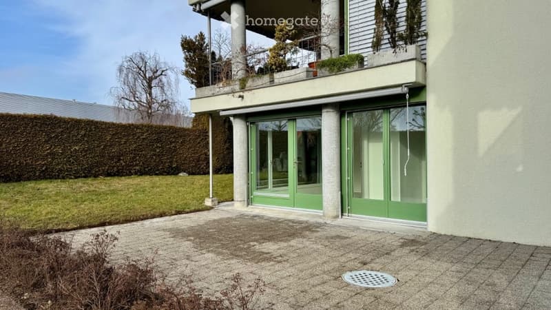 Modern house, green glass doors, balcony with plants, tiled patio